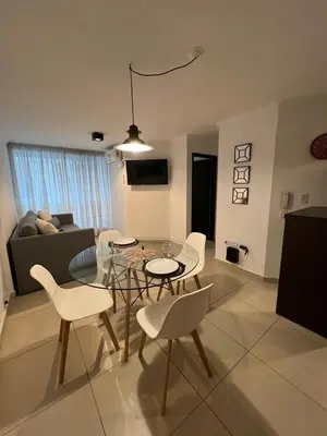 a living room with a glass table and white chairs at Departamento céntrico en Córdoba in Cordoba