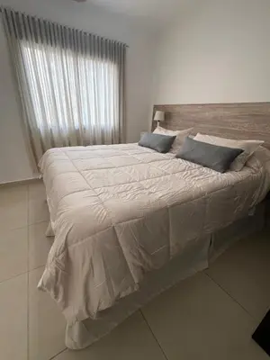 a large bed in a white room with a window at Departamento céntrico en Córdoba in Cordoba