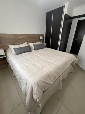a large bed in a bedroom with a large white comforter at Departamento céntrico en Córdoba in Cordoba