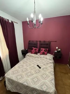 a bedroom with a bed with purple walls and a chandelier at Complejo con seguridad in Cordoba
