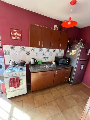 a kitchen with a stove and a sink and a refrigerator at Complejo con seguridad in Cordoba