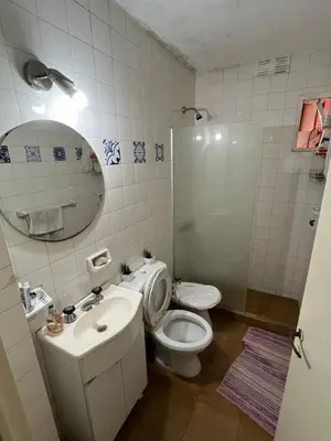 a bathroom with a toilet and a sink and a mirror at Complejo con seguridad in Cordoba