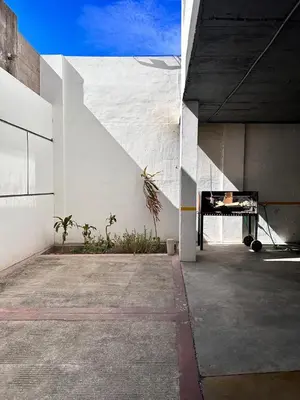 a large white building with a table in a courtyard at Departamento Estrada Lux Céntrico in Villa Carlos Paz