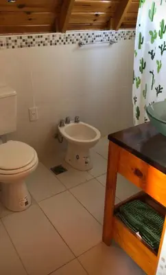 a bathroom with a toilet and a sink at Cabañas Las abuelas in Villa Rumipal