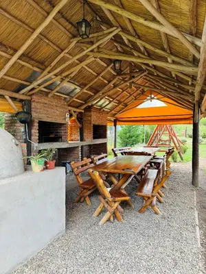 an outdoor patio with a wooden table and chairs at Cabañas Las abuelas in Villa Rumipal