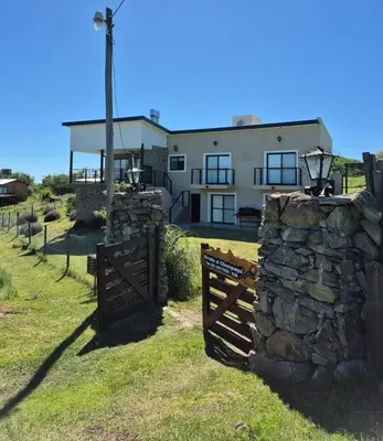 a house with a gate and a stone wall at Mirada al Champaquí - Chalet de Montaña in Villa Yacanto
