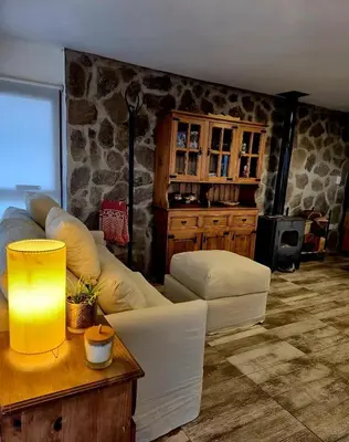 a living room with a white couch and a table at Mirada al Champaquí - Chalet de Montaña in Villa Yacanto