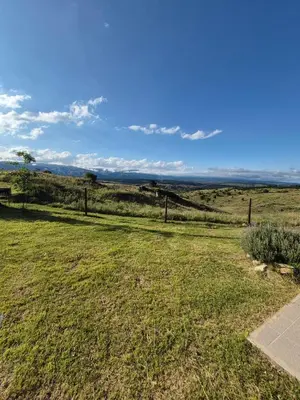 a grassy field with a fence in the distance at Mirada al Champaquí - Chalet de Montaña in Villa Yacanto