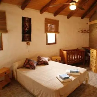 a bedroom with a bed with two books on it at Cabanas Parparim in Mina Clavero