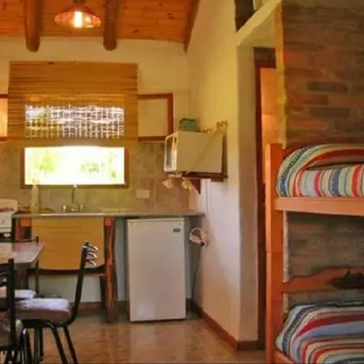 a small kitchen with a refrigerator and a bunk bed at Cabanas Parparim in Mina Clavero
