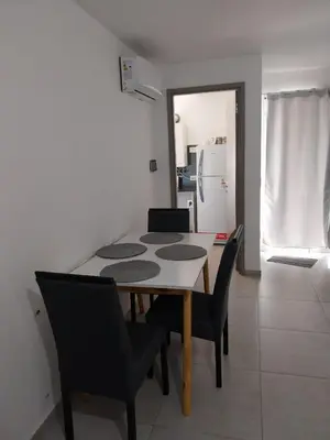 a dining room with a table and chairs and a refrigerator at Departamento en Edificio Fluss, Mariano Fragueiro 585 in Cordoba