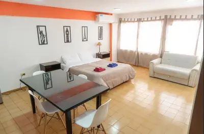 a bedroom with a bed and a table and chairs at Departamento Bv Chacabuco by INMOVE Temporarios in Cordoba