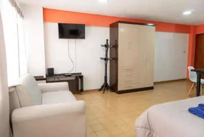 a living room with a white couch and a television at Departamento Bv Chacabuco by INMOVE Temporarios in Cordoba