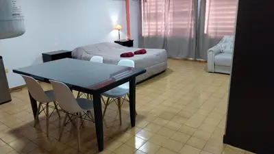 a bedroom with a bed and a table and chairs at Departamento Bv Chacabuco by INMOVE Temporarios in Cordoba