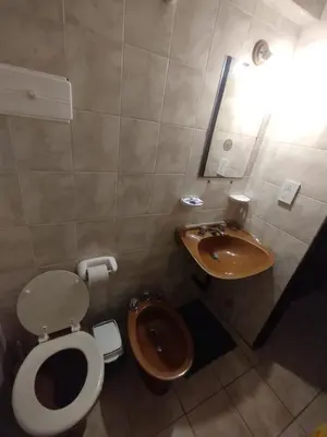 a bathroom with a toilet and a sink at Departamento Bv Chacabuco by INMOVE Temporarios in Cordoba