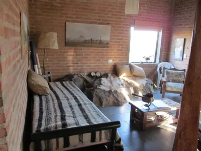 a bedroom with a bed and a brick wall at Alpa'y Kanki in Alpa Corral