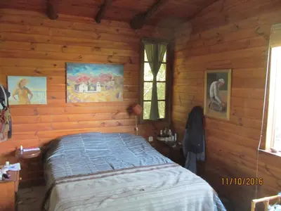 a bedroom with a bed in a log cabin at Alpa'y Kanki in Alpa Corral
