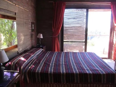 a bedroom with a bed with a large window at Alpa'y Kanki in Alpa Corral