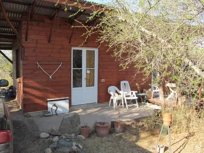 a wooden cabin with a patio and a table and chairs at Alpa'y Kanki in Alpa Corral