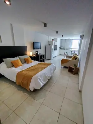 a bedroom with a large bed and a living room at Monoambiente excelente ubicación Cordoba Rent in Cordoba
