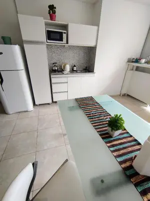 a kitchen with white appliances and a table in a room at Monoambiente excelente ubicación Cordoba Rent in Cordoba