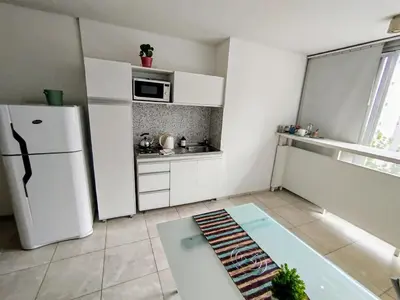 a white kitchen with a refrigerator and a table at Monoambiente excelente ubicación Cordoba Rent in Cordoba