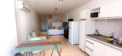 a kitchen with a white refrigerator and a room at Monoambiente excelente ubicación Cordoba Rent in Cordoba