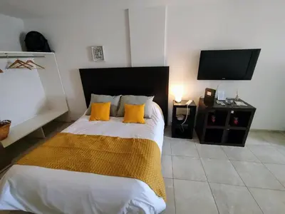 a bedroom with a bed with yellow pillows and a tv at Monoambiente excelente ubicación Cordoba Rent in Cordoba