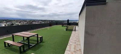 a balcony with tables and benches on top of a building at Miralejos 7 Music in Villa Carlos Paz