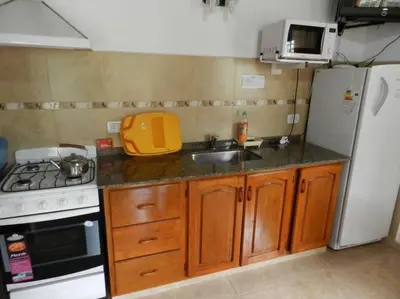 a kitchen with a sink and a stove and refrigerator at Duplex de la Virgen in Mina Clavero