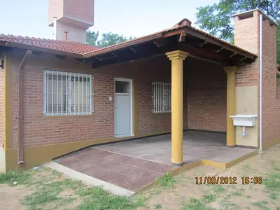a brick house with a porch and a white door at Duplex de la Virgen in Mina Clavero