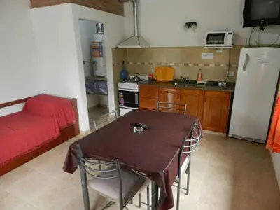 a small kitchen with a table and a refrigerator at Duplex de la Virgen in Mina Clavero