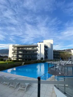a building with a large swimming pool in front of a building at departamento complejo Veneto Village con vista al lago in Villa Parque Siquiman