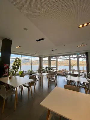 a dining room with tables and chairs and windows at departamento complejo Veneto Village con vista al lago in Villa Parque Siquiman