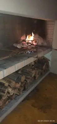 a fire in a brick oven with logs in it at Paraíso Serrano 6 in Villa Ciudad Parque