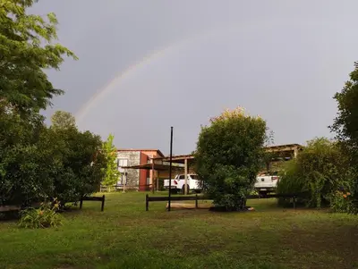 a rainbow in the sky over a yard with trees at Paraíso Serrano 6 in Villa Ciudad Parque