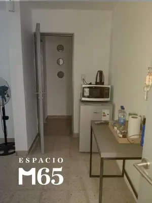 a small kitchen with a table and a microwave at M65 Luxury Suit in Cordoba