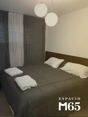 a bedroom with a large bed with two white pillows at M65 Luxury Suit in Cordoba