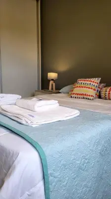 two beds with white sheets and a lamp in a room at Departamento Quirós in Cordoba