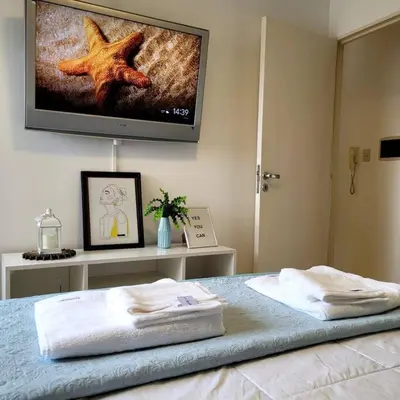 a bedroom with a bed with a television on the wall at Departamento Quirós in Cordoba