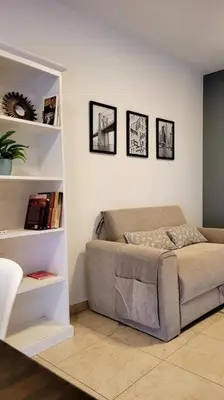 a living room with a couch and a book shelf at Departamento Quirós in Cordoba