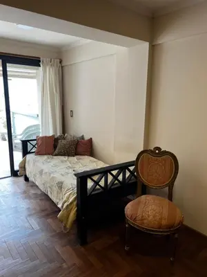 a bedroom with a bed and a chair and a window at San Lorenzo 137 in Cordoba