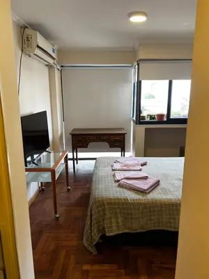 a room with a bed and a desk and a television at San Lorenzo 137 in Cordoba