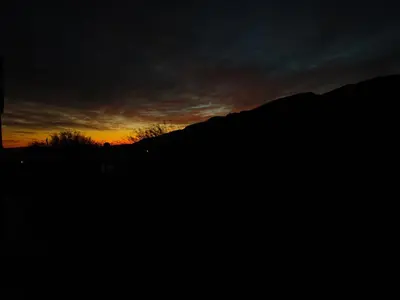 a sunset with a mountain in the background at La Deseada in Quines