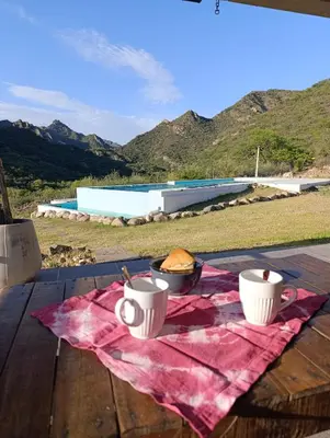 a picnic table with two cups and a bowl of food at La Deseada in Quines