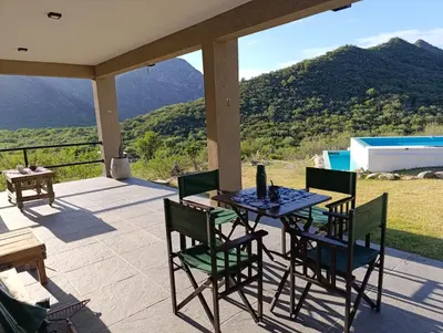 a table and chairs on a patio with a view at La Deseada in Quines