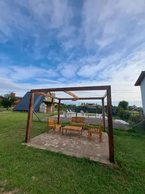 a group of benches sitting under a gazebo at Cabañas Aires De Luna in Los Reartes