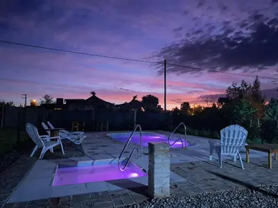 a patio with two chairs and a table with purple lights at Cabañas Aires De Luna in Los Reartes