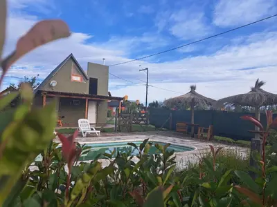 a backyard with a swimming pool and a house at Cabañas Aires De Luna in Los Reartes