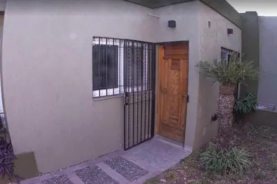 a house with a wooden door and windows at Monoambiente super funcional! in Cordoba